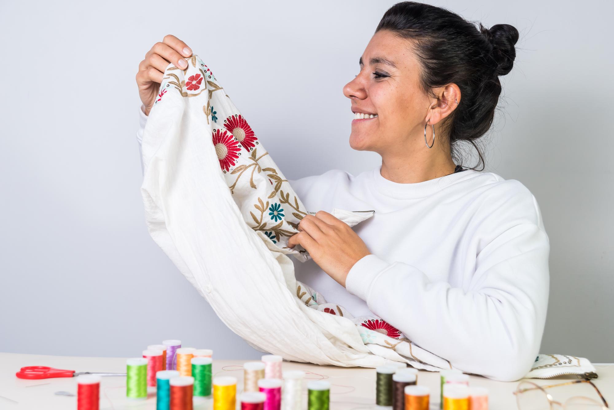 artisan at work holding embroidered garment